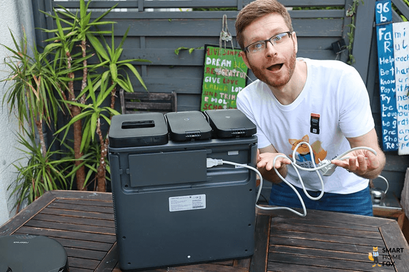 Ilia is als Smart Home Fox Team Member mit einem Saugroboter in der Hand zu sehen